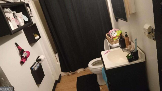 full bath featuring vanity, toilet, and wood finished floors