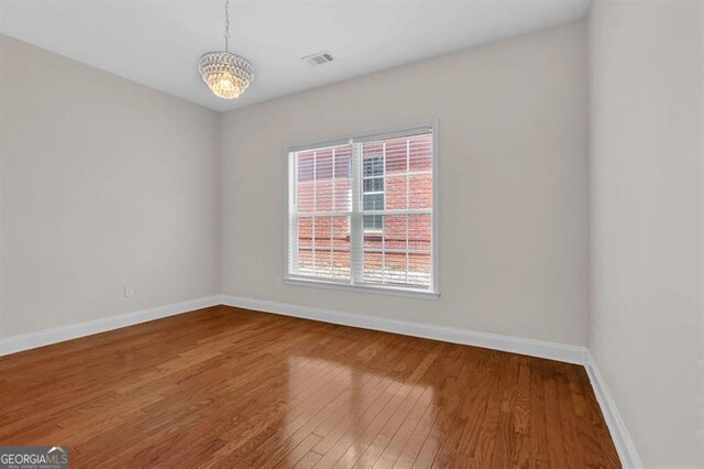 735 Scenic Creek Dr, Lawrenceville, GA 30046 - spare room featuring wood finished floors and a chandelier