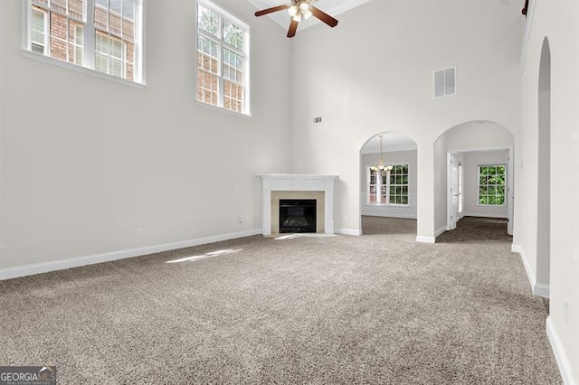 735 Scenic Creek Dr, Lawrenceville, GA 30046 - unfurnished living room with carpet flooring, ceiling fan, a high ceiling, arched walkways, and a glass covered fireplace