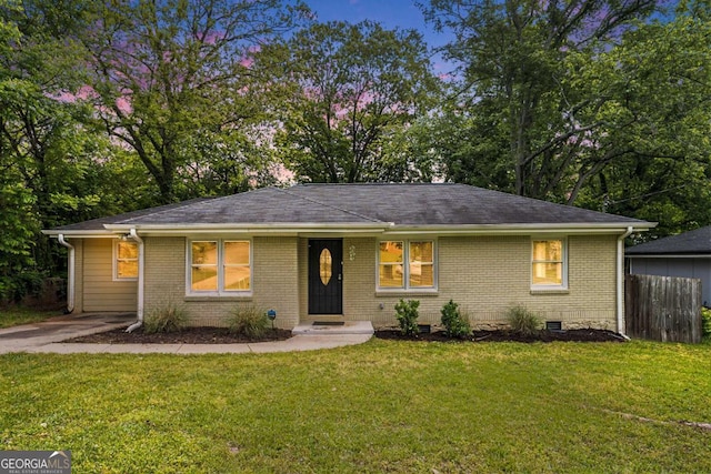 single story home featuring fence, brick siding, and a front yard