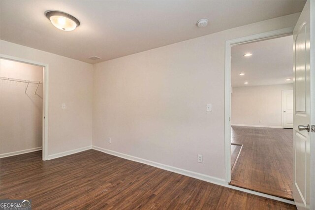 unfurnished bedroom with recessed lighting, baseboards, wood finished floors, and a closet