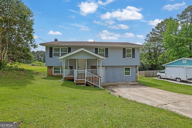 raised ranch featuring a porch, a patio, and a front lawn