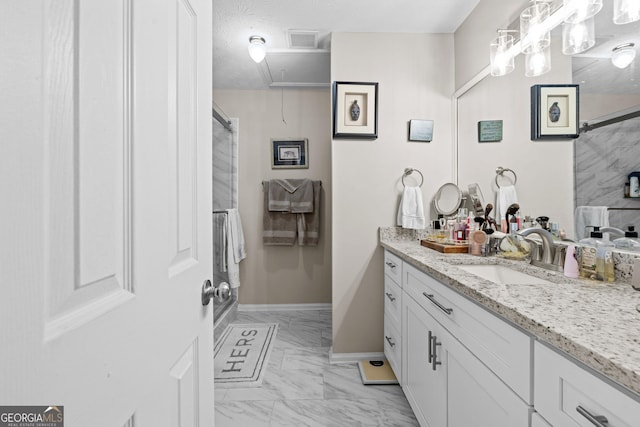 bathroom featuring baseboards, walk in shower, marble finish floor, and vanity