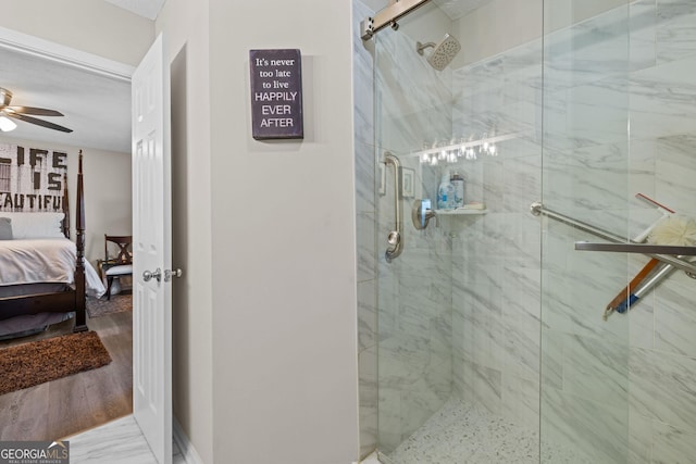ensuite bathroom featuring connected bathroom, ceiling fan, and a shower stall