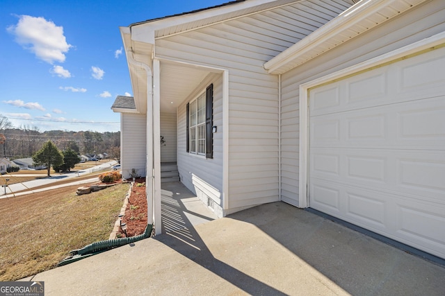 view of exterior entry featuring concrete driveway