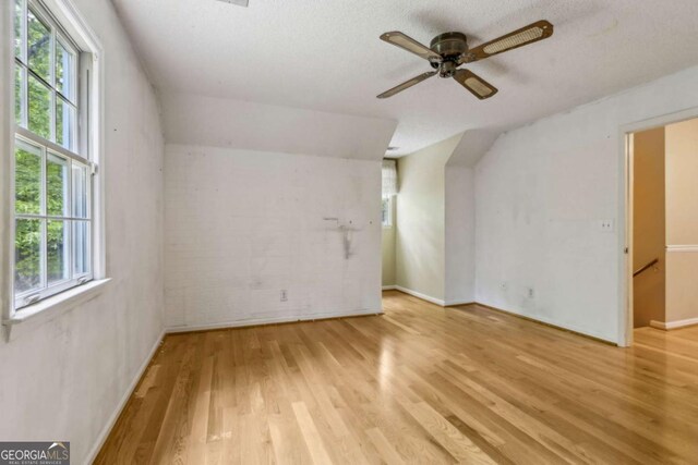 bonus room featuring a healthy amount of sunlight, baseboards, ceiling fan, and wood finished floors