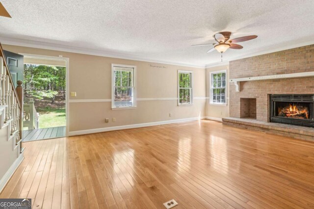 unfurnished living room with a textured ceiling, ceiling fan, and light wood finished floors