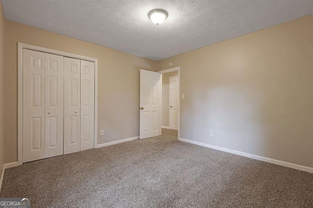 785 Redland Dr, Jonesboro, GA 30238 - unfurnished bedroom with a textured ceiling, carpet flooring, and a closet