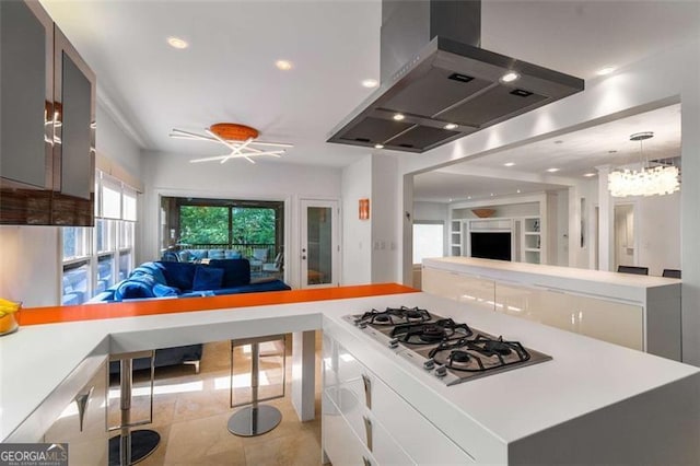 kitchen featuring range hood, open floor plan, white gas cooktop, a ceiling fan, and light countertops