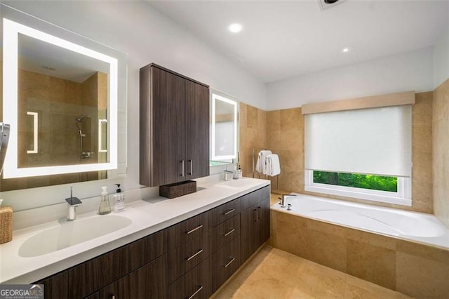 bathroom with a garden tub, a tile shower, double vanity, tile patterned floors, and recessed lighting