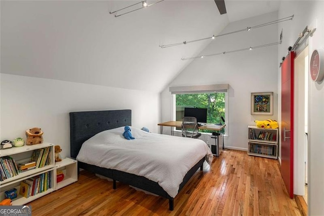 bedroom featuring wood finished floors, vaulted ceiling, and ceiling fan