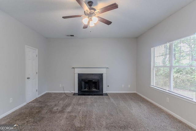 2319 Rambling Way, Lithonia, GA 30058 - unfurnished living room with healthy amount of natural light, carpet flooring, ceiling fan, and a fireplace with flush hearth