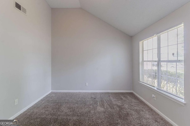 unfurnished room with vaulted ceiling, carpet flooring, and baseboards