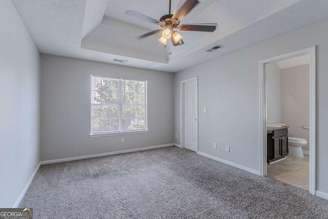 2319 Rambling Way, Lithonia, GA 30058 - unfurnished bedroom with light colored carpet, a raised ceiling, a textured ceiling, ensuite bathroom, and a ceiling fan