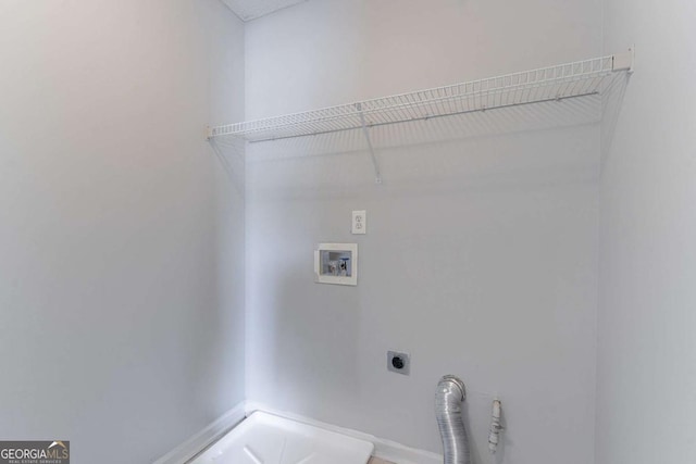 clothes washing area featuring hookup for an electric dryer, hookup for a washing machine, and baseboards