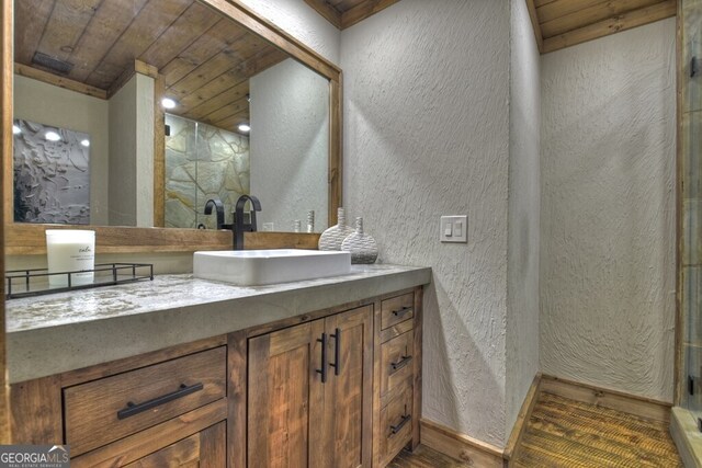 full bathroom with wood ceiling, a stall shower, wood finished floors, vanity, and a textured wall
