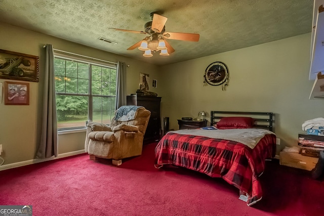 bedroom with ceiling fan, a textured ceiling, visible vents, baseboards, and carpet flooring