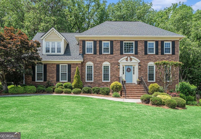 view of front of house featuring brick siding and a front lawn