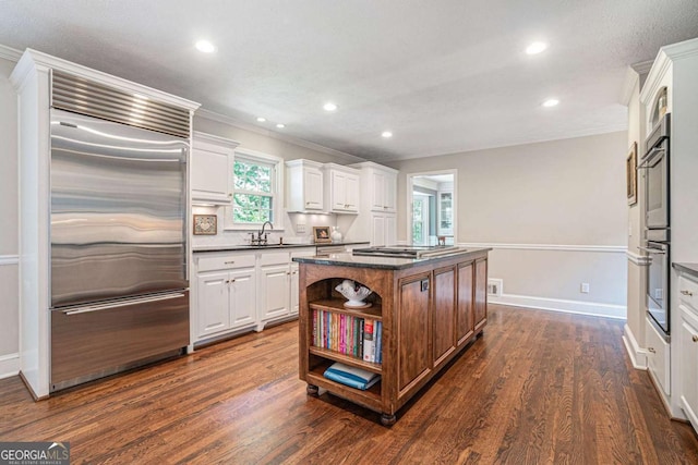kitchen with crown molding, open shelves, stainless steel appliances, white cabinetry, and a kitchen island