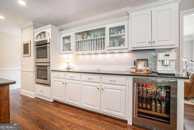 kitchen with crown molding, dark wood finished floors, double oven, beverage cooler, and recessed lighting