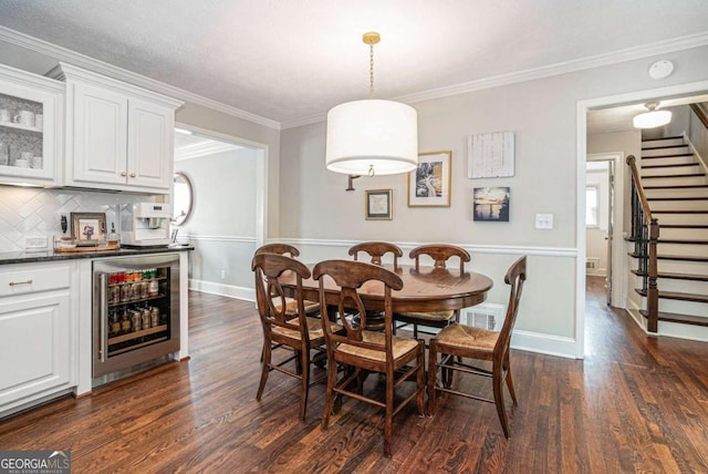 dining area featuring dark wood finished floors, stairway, baseboards, beverage cooler, and ornamental molding