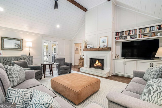 living room featuring wood ceiling, ceiling fan, a decorative wall, and wood finished floors