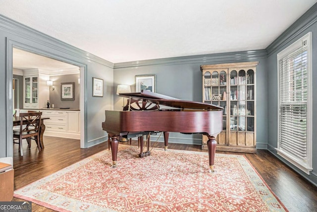 living area featuring dark wood-type flooring, baseboards, and crown molding