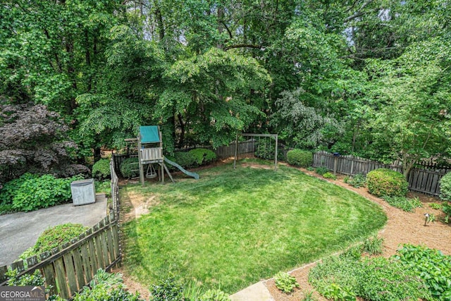 view of yard with a fenced backyard and a playground
