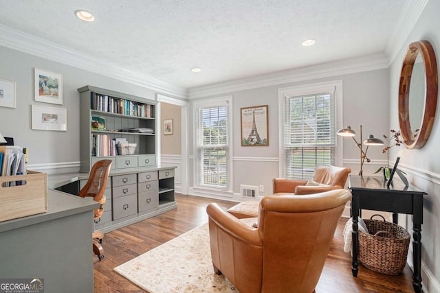 office space with visible vents, ornamental molding, a textured ceiling, and wood finished floors