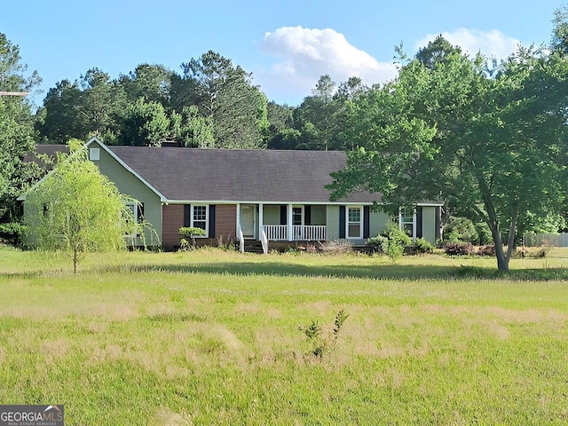 ranch-style home with covered porch and a front yard