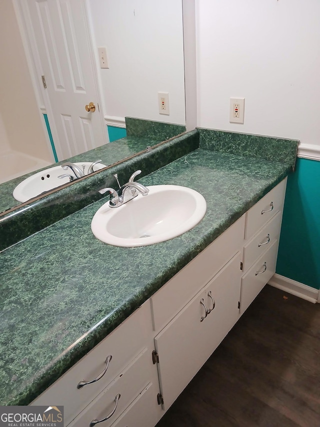 bathroom with vanity, baseboards, and wood finished floors