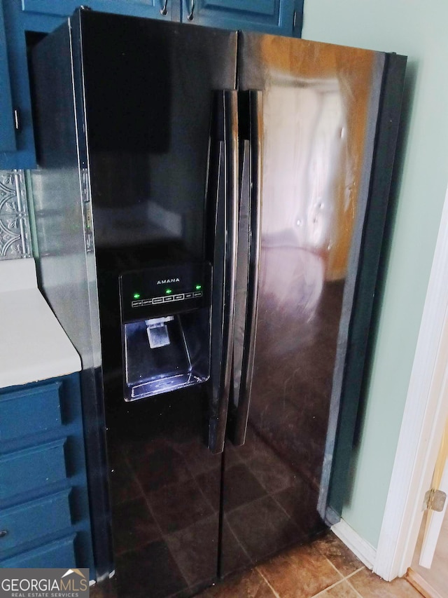 kitchen featuring black fridge with ice dispenser and blue cabinets