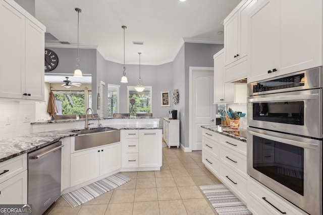 kitchen featuring backsplash, a sink, light tile patterned floors, white cabinets, and stainless steel appliances