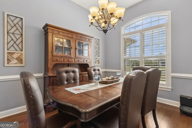 dining space with baseboards, hardwood / wood-style flooring, and a notable chandelier