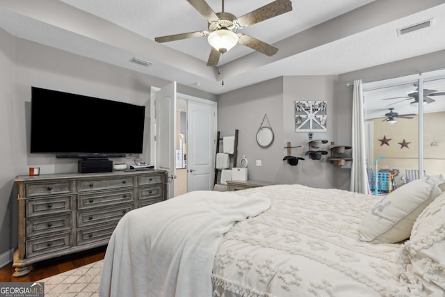 bedroom featuring visible vents, a ceiling fan, baseboards, and wood finished floors