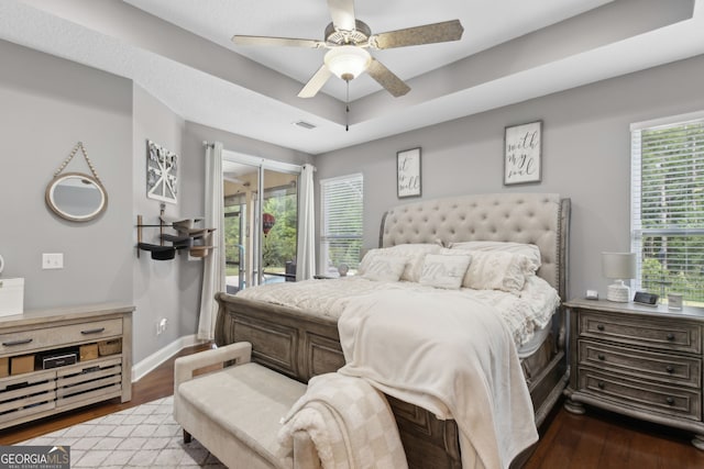 bedroom featuring a ceiling fan, baseboards, visible vents, and wood finished floors