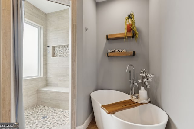 full bathroom with a freestanding bath and tiled shower
