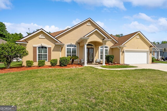 view of front of home featuring a garage, stucco siding, a front yard, french doors, and driveway