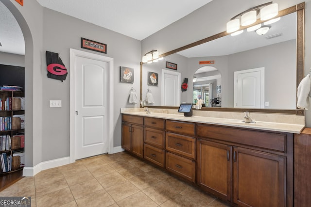 bathroom with a sink, tile patterned floors, double vanity, and visible vents