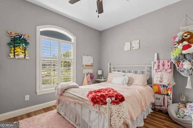 bedroom with baseboards, a ceiling fan, and wood finished floors