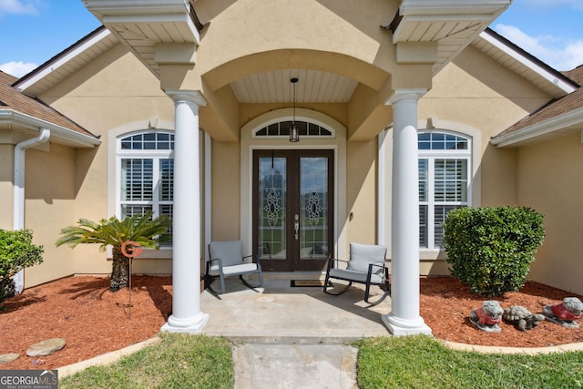 doorway to property featuring french doors and stucco siding