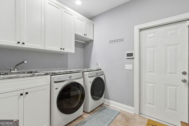 laundry area with washer and dryer, baseboards, a sink, and cabinet space