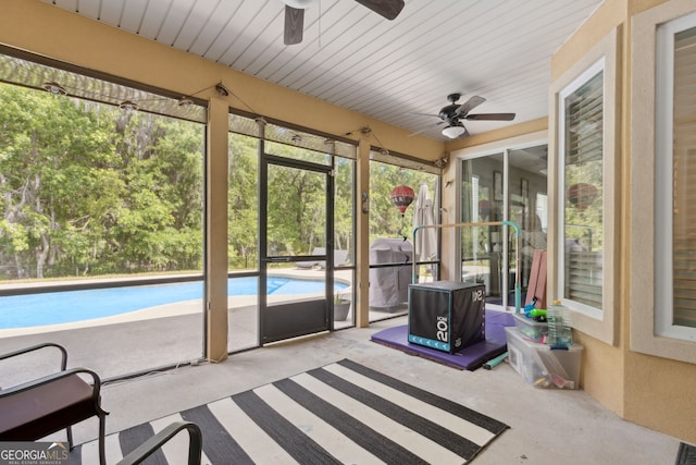 unfurnished sunroom with a ceiling fan