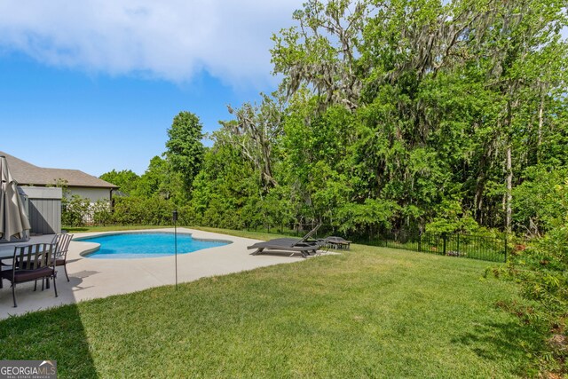 view of swimming pool featuring a lawn, a fenced in pool, a fenced backyard, and a patio area
