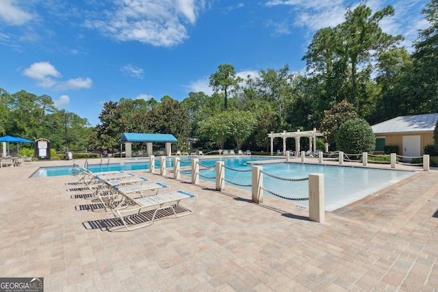 community pool with a patio area and a pergola