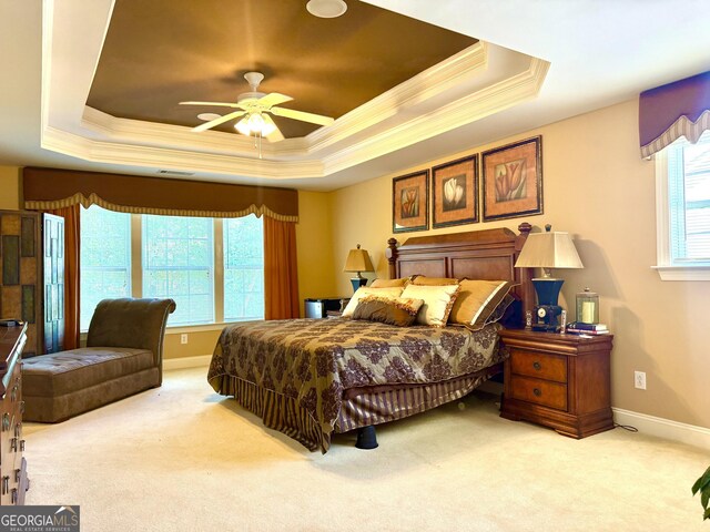 carpeted bedroom featuring a ceiling fan, visible vents, crown molding, a raised ceiling, and baseboards