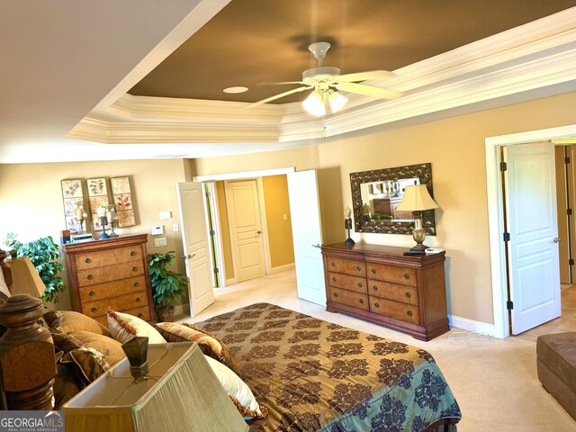 bedroom with crown molding, ceiling fan, light colored carpet, baseboards, and a tray ceiling