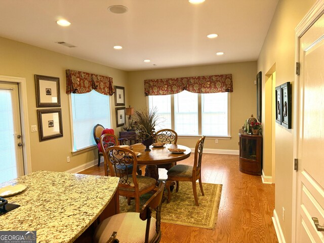 dining space with recessed lighting, baseboards, wood finished floors, and visible vents