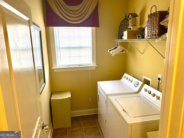 washroom featuring laundry area, washer and clothes dryer, baseboards, and dark tile patterned flooring