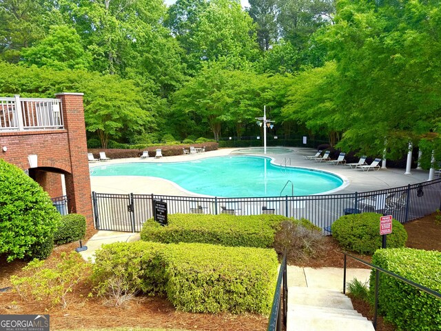 pool with fence and a patio area